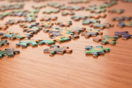 Puzzles on a wooden surface closeupの写真素材