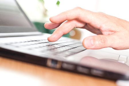 Hand on the laptop keyboard closeup