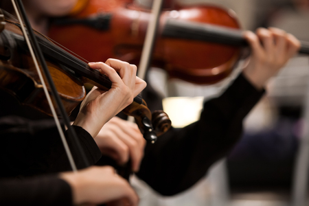 Hands of a girl playing the violin in the orchestraの写真素材