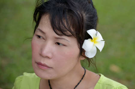 Asian woman with white flowers in her hairの写真素材