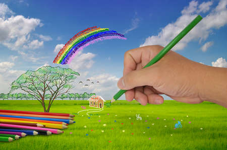 hand with pencil painting on fieldの写真素材