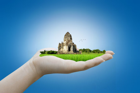 hand holding historic site, Phra Prang Sam Yot temple in thailandの写真素材
