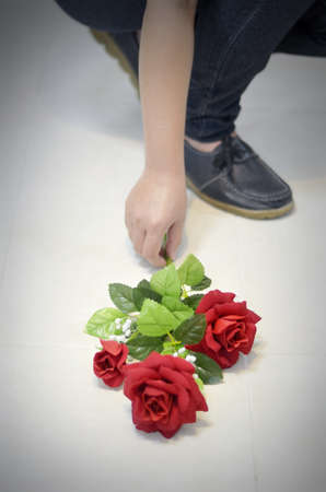 human with red rose flower on floorの写真素材