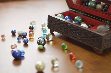 glass marble balls on table with antique wooden boxの写真素材