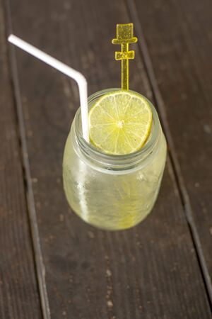 Lime juice with ice and straw in glass jarの写真素材