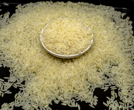 Raw Jasmine Rice seed in bowl isolated in black background, signature of Thailandの写真素材