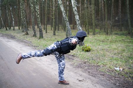 a lonely S.W.A.T ranger in the forest standing on one leg