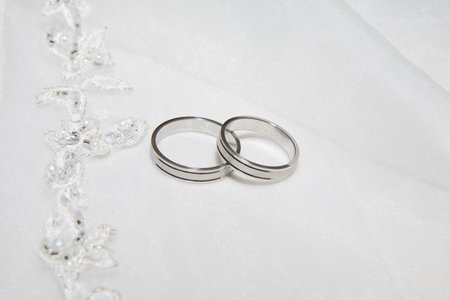 two wedding rings photo taken on some satin fabricの写真素材