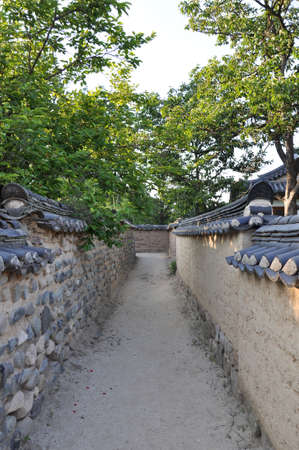 narrow path with wall featuring traditional hanok roof tiles in hahoe folk village, andong, south koreaのeditorial素材