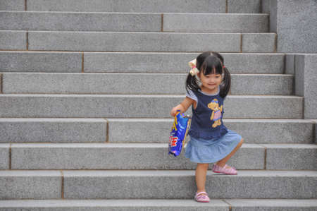 SEOUL, SOUTH KOREA - AUGUST 2012 - Ewha Womans University little girl playing on steps of Campus Complex (ECC) building.のeditorial素材