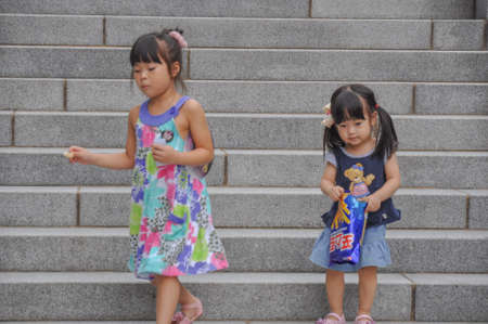 SEOUL, SOUTH KOREA - AUGUST 2012 - Ewha Womans University little girl playing on steps of Campus Complex (ECC) building.のeditorial素材
