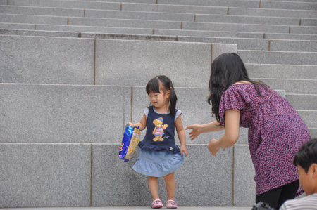 SEOUL, SOUTH KOREA - AUGUST 2012 - Ewha Womans University little girl playing on steps of Campus Complex (ECC) building.のeditorial素材
