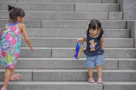 SEOUL, SOUTH KOREA - AUGUST 2012 - Ewha Womans University little girl playing on steps of Campus Complex (ECC) building.のeditorial素材