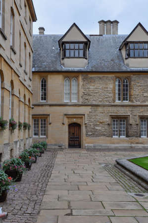 View of lawn and building facade with decorative planting from Hertford College Old Quad, Oxford, United Kingdom. Overcast Sky.のeditorial素材