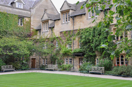 View of lawn and building facade with decorative planting from Hertford College Old Quad, Oxford, United Kingdom. Overcast Sky.のeditorial素材