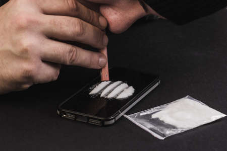 addict uses drugs using a mobile phone or smartphone. alone addict people.の写真素材
