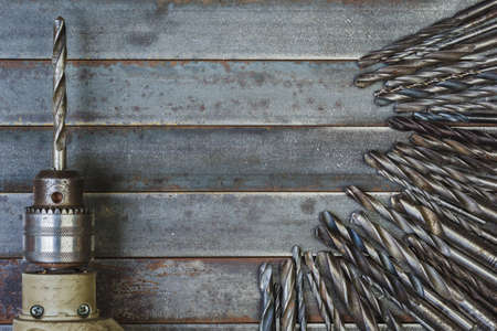Drill and drill bits old metal background .
