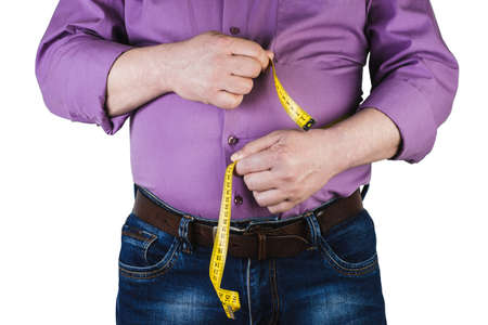 Thick mature man measuring his belly with a measuring tape, isolated on white background. Not proper nutrition.の写真素材