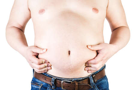Excess body weight of a man with his hands touching fat on his stomach is the concept of obesity. Not the right food.の写真素材