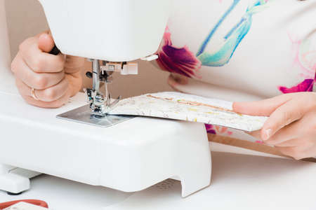 Female hands working for the white sewing machine. Scrapbooking for wedding or other festive...