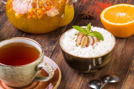 Fresh fruit salad, cream in a bowl and fruit on a wooden background.の写真素材