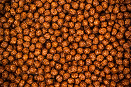 Chocolate breakfast cereal texture. Cereal balls as background. Chocolate corn balls .の写真素材