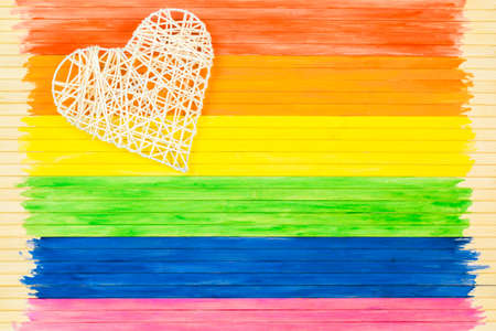 People, gay pride parade, braided heart, and homosexual concepts on the background of the rainbow flag strip.の写真素材