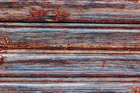 Red board wall of an old barn. Textured and flaking red paint from old farm building.