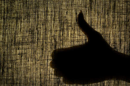 The shadow hand shows the gesture well, like a gesture on a worn cloth.の写真素材