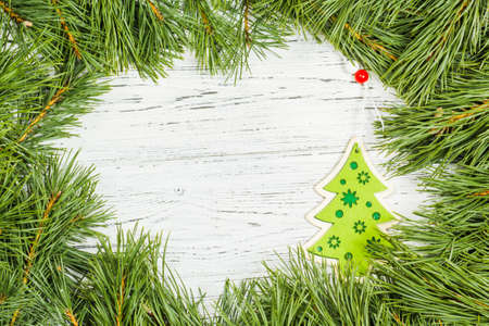 Frame of fir branches with Christmas decorations on old wooden table. Space for text. Top view.の写真素材