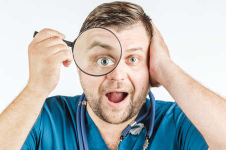 doctor using a magnifying glass on a white backgroundの写真素材