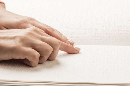Books Braille. The touch of your fingertips the texture of the paper, reading the sign. Reading the book blind man.の写真素材