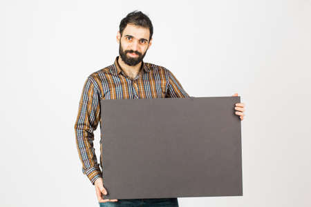 Portrait of a bearded businessman holding a black blank panel with space for text. Isolated on white background.の写真素材