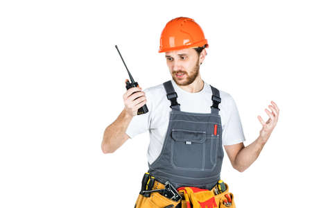 The builder talks, swears on thewalkie-talkie. isolated on white background.の写真素材