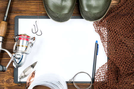Fishing gear - fishing, fishing, hooks and baits, an of paper on a wooden background.の写真素材