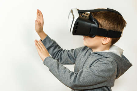 Boy with a headset of virtual reality. Innovative technology. On an white background.