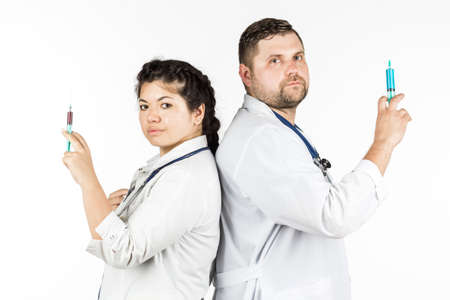 Young female nurse and male doctor with syringes in hands. on a white background.の写真素材