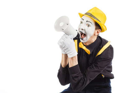 Portrait of a male mime artist, shouting or showing on a megaphone. Isolated on white background.の写真素材
