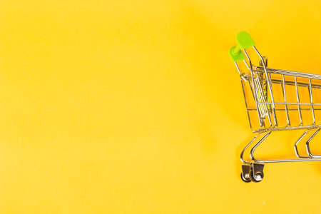 grocery cart on a yellow background, concept of buying business finance.の写真素材