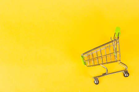 grocery cart on a yellow background, concept of buying business finance.の写真素材