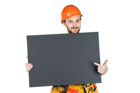 Full length portrait of a male construction worker with a white blank banner over a white wall...