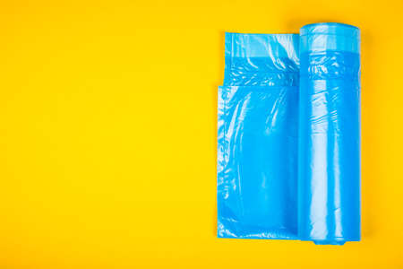 New blue garbage bags on a yellow background.の写真素材
