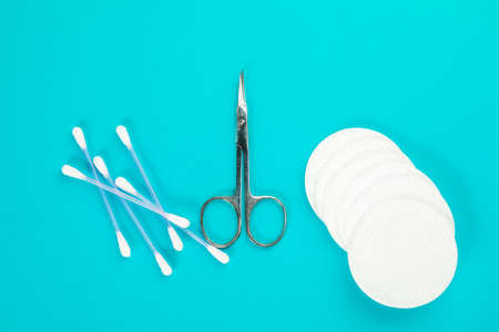 Scissors, cotton swabs and pads on a blue background. hygiene products.の写真素材