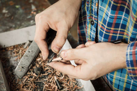 Sharpening a pencil with a stationery knifeの写真素材