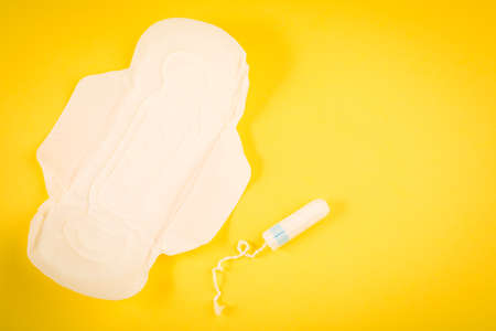 Sanitary pads and tampon on a yellow background. hygiene products.の写真素材