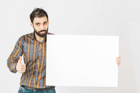 Portrait of a bearded businessman holding a white  blank panel with space for text. Isolated on...