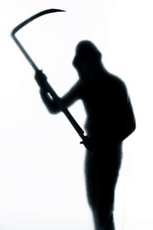 Dangerous man behind frosted glass with a scythe in his hand. Halloween. Black and white imageの写真素材
