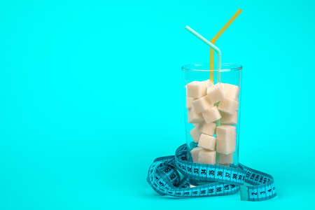 A glass of sugar cubes-the concept of unhealthy eating. On a blue background.の写真素材