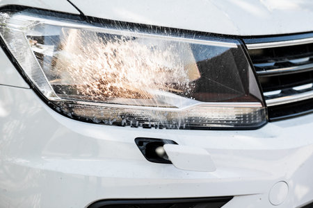 Headlight with a wiper detail on a car pollution. car wash.