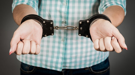 A young woman was arrested and handcuffed.